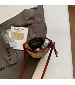 Detail view of straw bucket bag interior showing capacity for phone and cosmetics