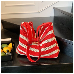Detail of red and white striped knit tote with leather handle and wooden horn button closure