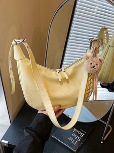 Large pale yellow dumpling bag with crocodile embossing and a cute bear charm for women
