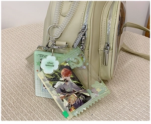 Macro shot of mint green backpack featuring clear PVC pocket and anime character card