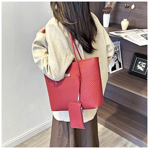 Detail of red chevron tote bag with matching pouch on beige blazer outfit