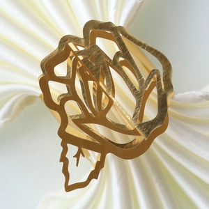 Detailed macro view of the hollow golden rose napkin ring with a polished metallic finish
