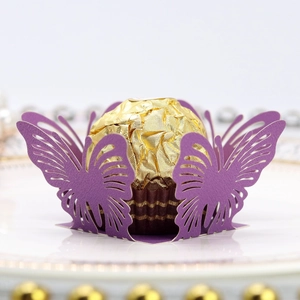 Vista macro dell'involucro per cupcake a farfalla viola tagliato al laser su un piatto