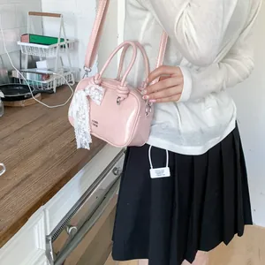 Rosa Lackleder-Boston-Tasche mit weißer Spitzenschleife in einer gemütlichen Küche