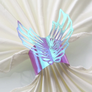 Iridescent laser-cut butterfly napkin ring with gradient purple and blue wings on silk
