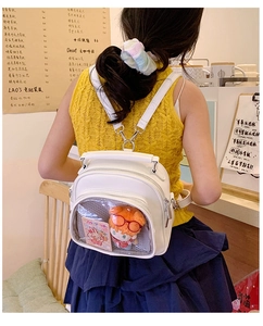 White leather ita bag with transparent window showing a plush doll in a cafe setting