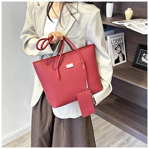 Detail of red tote bag featuring herringbone texture and matching pendant pouch accessory