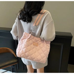 Makroansicht der rosa gesteppten Shopper-Tasche mit Rautenmuster und Kettenriemendetail