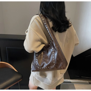 Vue détaillée du grand sac cabas en cuir marron vintage avec rivets métalliques stylés