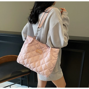 Detail der rosa gesteppten Shopper-Tasche mit YPSF-Logo und Rautenmuster am Modell