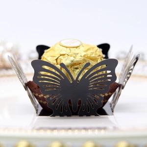 Detail of laser-cut black butterfly cupcake liner holding a gold foil chocolate ball