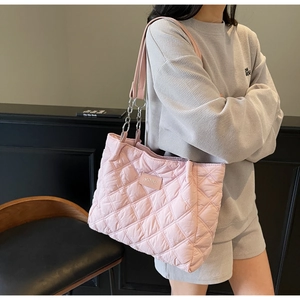 Detail der rosa gesteppten Shopper Tasche mit Kettenriemen und dezentem Logo-Patch