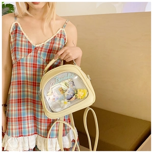 Detail of cream Ita bag with clear window showing plush bunny and anime cards