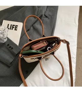Top view showing spacious interior of woven straw handbag with brown leather straps