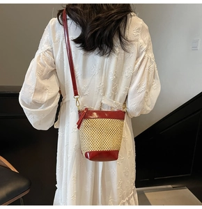 Detailed back view of a mini straw bucket bag with red leather trim on a model
