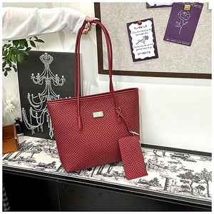 Detail of red tote bag set featuring large shoulder bag and small matching pouch