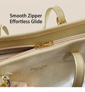 Close-up of smooth gold zipper and crocodile pattern on beige tote bag surface