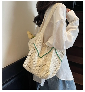 Detail of crochet tote bag showing woven cream texture and green wavy scalloped edges