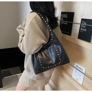 Détail du sac hobo en cuir PU noir avec rivets punk argentés et bandoulière réglable chic