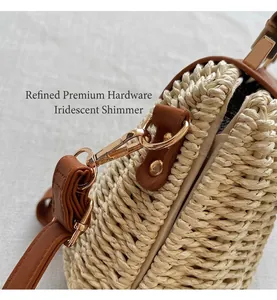 Detail of woven straw bag showing golden buckle, brown leather trim, and fine texture