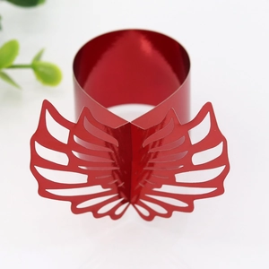 Close-up of red paper napkin ring with hollow butterfly wings and metallic finish
