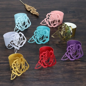 Detailed laser-cut paper napkin rings in diverse colors on a dark wooden table