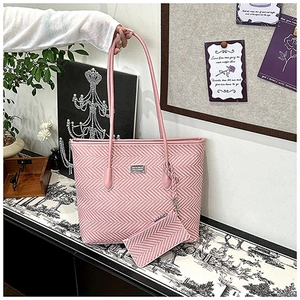 Detail of pink chevron tote bag and matching small pouch with elegant metal logo