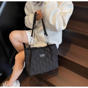 Detailaufnahme der schwarzen gesteppten Shopper-Tasche aus Nylon mit Silberketten