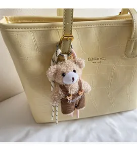 Detail of plush bear charm with corduroy overalls as a decorative accessory for tote bags