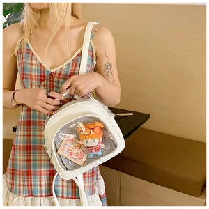 Close-up of a white leather Ita bag featuring a clear display window and adjustable strap