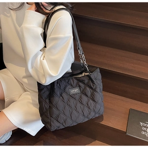 Detail der schwarzen Stepptasche mit YPSF-Logo und Leder-Metall-Kettenriemen am Modell