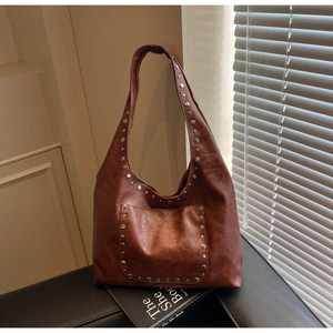 Détails du sac cabas marron en cuir avec clous argentés et texture huilée vintage