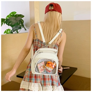 Rear view of a white PU leather Ita bag with clear PVC window and cute plushies inside