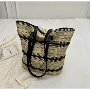 Détail du grand sac cabas en paille tissée avec rayures noires et anses en cuir