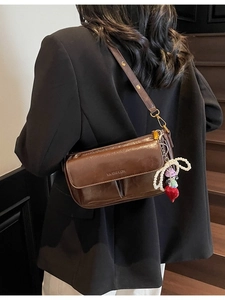 Retro brown glossy leather shoulder bag with decorative pendants and gold hardware