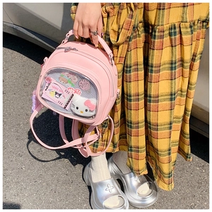 Detail of pink ITA bag transparent window with plush characters and badges inside