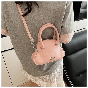 Pink shell bowling bag with pebble leather texture and metal logo plate on model