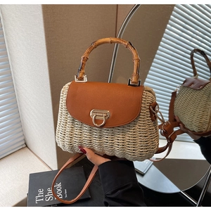 Detail of hand-woven straw crossbody bag with bamboo handle and brown leather flap