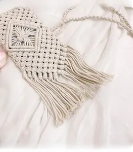 Close-up of cream handmade woven cotton bag showing geometric texture and long tassels