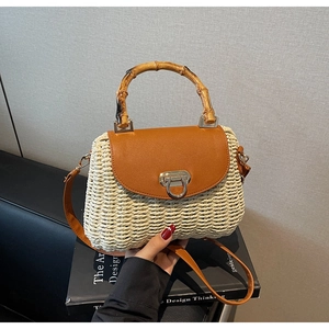 Close-up of retro straw crossbody bag with bamboo handle and golden horseshoe buckle