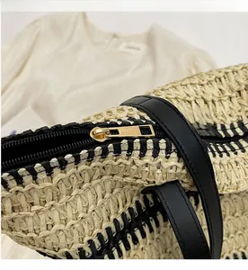 Détail de la fermeture éclair en métal doré et des finitions en cuir noir du sac tissé