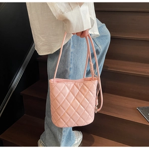 Vista dettagliata della borsa a secchiello rosa trapuntata con cuciture a rombi