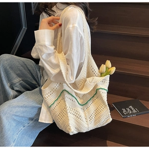 Detail of cream crochet tote bag with green wave patterns and large capacity texture
