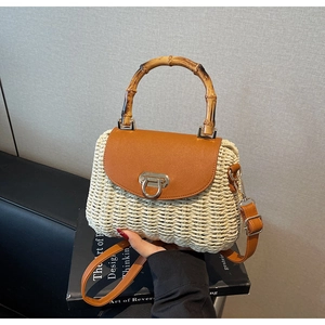 Detail of woven straw handbag featuring vintage bamboo handle and brown leather flap