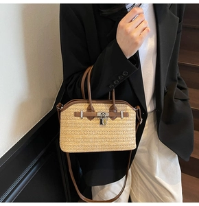 Detail of woven straw handbag featuring vintage leather trim and iconic silver padlock