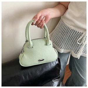 Detail of light green pebble leather handbag with silver hardware and top handle