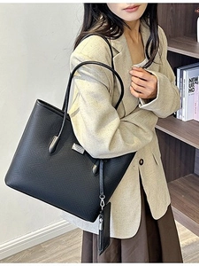 Large black textured tote bag with silver logo detail and matching mini pouch accessory