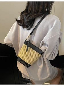 Crossbody straw bag with black leather trim and gold hardware for beach vacation