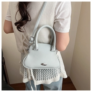 Detail of light blue shell crossbody bag with lychee texture on model back view