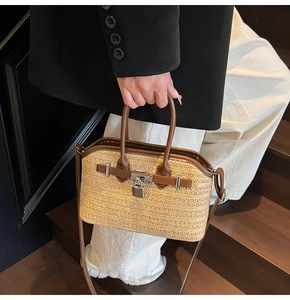 Detail of woven straw handbag featuring silver padlock closure and brown leather trim